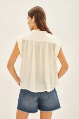 Camisa color crudo de corte amplio con mangas cortas y cuello mao, confeccionada en viscosa y modal.