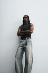 Pantalón de jean celeste con efecto lavado, corte holgado desde la cadera que se estrecha ligeramente en el bajo, tiro medio, cinco bolsillos y cierre frontal con cremallera y botón.