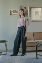 Pantalón negro de tiro medio con cierre lateral y pierna ancha. Presenta un lazo cruzado en la parte delantera.