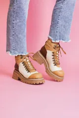 Botas de cuero color blanco, marrón y beige, con cordones y suela track.