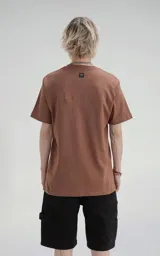 Remera color marrón claro de manga corta, cuello redondo y calce regular con recorte en espalda, realizada en algodón premium muy suave al tacto.