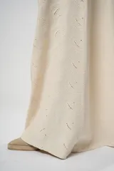 Pantalón palazzo color beige con bordados calados en forma de paisley en los laterales.