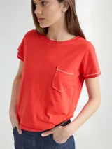 Remera roja de algodón con bolsillo en el pecho y bordes con costuras a contratono.