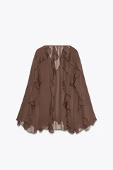 Blusa marrón de gasa con escote en V y manga larga abullonada. Presenta volantes en el mismo tejido y cierre frontal con botones.