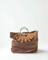 Cartera marrón de cuero con flecos y doble asa circular metálica.