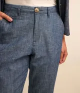 Pantalón recto de jeans azul con bolsillos y bajo plegado.