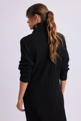 Vestido largo negro de punto canale con cuello alto y mangas largas.