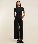 Blusa negra ajustada de microfibra con cuello redondo y mangas cortas. Presenta fruncido en el lateral y encaje en el bajo.
