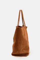 Bolso tipo maxi shopper color marrón, confeccionado en ante. Tiene doble asa de hombro y bolsillo interior con cremallera.