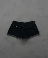 Short de jean negro con tachas plateadas en los laterales y ruedo desflecado.