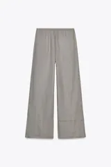 Pantalón palazzo color ladrillo, confeccionado en lino 100%, de tiro medio, cintura ajustable con cordones, bolsillos laterales ocultos y pierna ancha.
