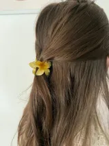 Pinza para el pelo con forma de flor amarilla.