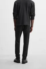 Pantalón de jean azul oscuro, corte slim fit, tiro medio, cinco bolsillos, tejido elástico y efecto lavado.