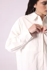 Camisa celeste de corte amplio, con cuello clásico, mangas largas y bolsillo en el pecho.