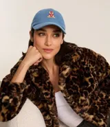 Gorra de jean celeste con visera curva y bordado de un oso en el frente.