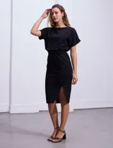 Vestido midi negro de crepe con escote a la base, mangas cortas japonesas, corte en la cintura elastizada con lazo de ajuste y tajo en la delantera.