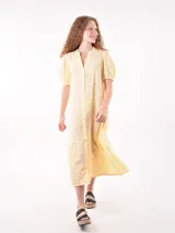 Vestido midi amarillo pastel con bordado calado, cuello mao, mangas cortas abullonadas y falda escalonada.