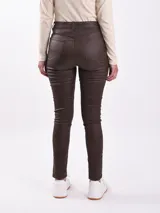 Pantalón chupín de cuero sintético color negro, tiro alto y corte ajustado.