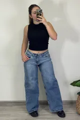 Pantalón jean celeste de tiro medio, corte ancho y estilo baggy.
