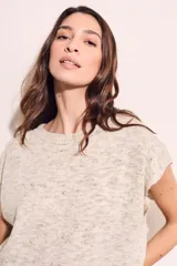 Chaleco de punto color beige con cuello redondo y mangas cortas.