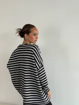 Sweater de punto a rayas horizontales blancas y negras, de corte holgado y mangas largas.