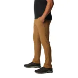 Pantalón de trekking color marrón claro, con protección solar UPF 50, repelente al agua y a las manchas. Cuenta con rodillas articuladas, puños cónicos, bolsillos con cremallera y detalles reflectantes.