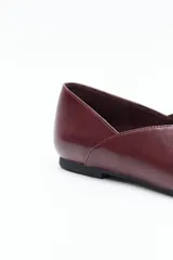 Zapato bajo de punta fina, color marrón oscuro, de acabado liso y estructura flexible.