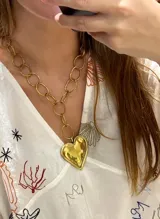 Collar dorado con cadena de eslabones grandes y dije de corazón martillado.
