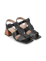 Sandalias negras de cuero con tiras cruzadas, hebilla lateral y tacón geométrico de madera.