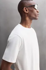 Camiseta blanca de corte holgado, cuello redondo y manga corta. Detalle de logo estampado en el bajo. Zara Athleticz.