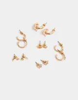 Set de seis pares de aros dorados con diferentes dijes: ojos, lunas, estrellas con strass y argollas con detalles esmaltados y strass.