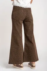 Pantalón de jean marrón con estampado animal print, corte flare y tiro medio.
