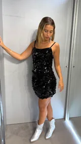 Minivestido negro con lentejuelas, de breteles finos y corte ajustado.