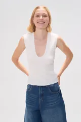 Musculosa negra de poliéster con textura arrugada, breteles anchos y escote en V profundo.