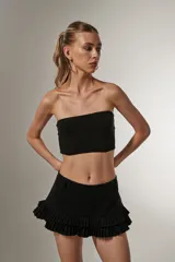 Top cropped negro de poliamida y lurex, al cuerpo, con elástico y cuello strapless.