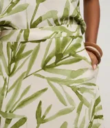 Pollera midi evasé de mujer, con cintura elástica y estampado de follaje en tonos verdes sobre fondo blanco.