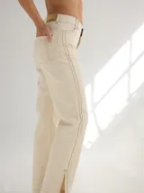 Pantalón negro de gabardina con alforzas verticales en los laterales y aberturas en los tobillos.