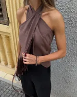 Top de gamuza marrón con flecos, cruzado y atado en el cuello.