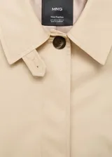 Chaqueta corta de algodón y poliéster color beige, con cuello camisero, cierre frontal de botones y diseño oversize. Posee mangas largas con trabillas ajustables y dos bolsillos laterales.