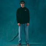 Canguro negro con capucha y bolsillo delantero, con cordones ajustables y puños elásticos. Estampado pequeño en el pecho con un personaje fumando.