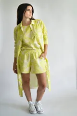 Short de lino y algodón color blanco con estampado de flores en verde lima, con elástico en la cintura y bolsillos laterales.