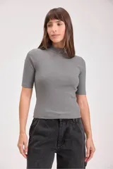 Remera gris de punto con cuello alto y mangas cortas.