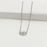 Colgante con forma de ojo turco estilizado, con pestañas marcadas, en metal plateado.