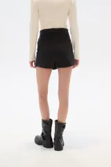 Short de jean azul con corte evasé y diseño cruzado.