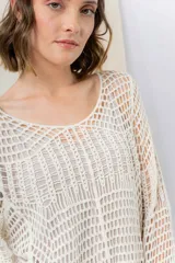 Sweater tejido calado color crudo, con escote amplio y mangas largas con caída relajada.