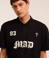Remera boxy de mangas cortas, confeccionada en algodón, color negro, con cuello polo y lettering "93 MAD" y una cruz estampada en la parte delantera.