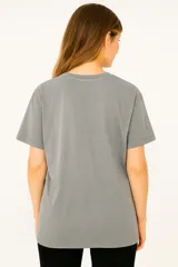 Remera gris oscuro con estampa frontal con la frase "Punk is not dead" en letras rosas y blancas.