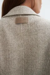 Tapado corto entallado color marrón claro con textura de espiga, cuello solapa y manga larga. Cierre frontal con botones.