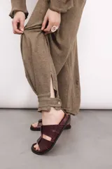 Pantalón de lino azul con tiro medio, elástico y lazo en la cintura, y puño con botón de nácar en el tobillo.