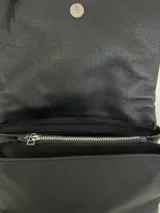 Cartera bandolera negra de cuero con correa ajustable y múltiples compartimentos.